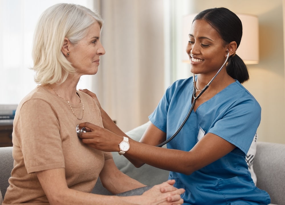 Certified Nursing Assistant assisting a senior patient during a health checkup.