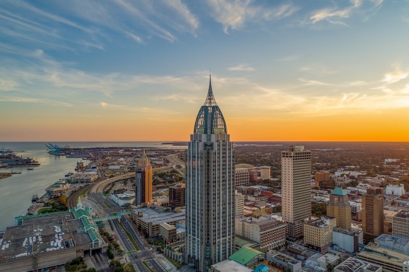 Aerial view of downtown Mobile, Alabama at sunset with waterfront skyline and skyscrapers