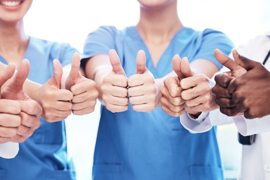 Group of CNA students and healthcare professionals giving thumbs up in support of training success