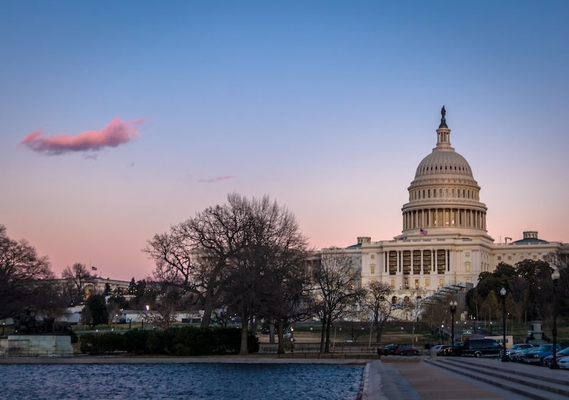 U.S. Capitol building at dusk with soft sunset colors and reflections in Washington DC