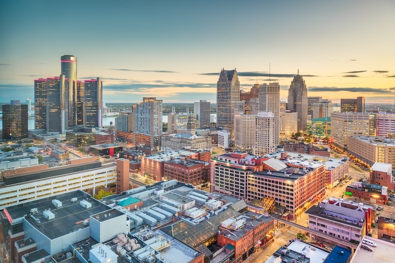 Evening skyline of downtown Detroit, Michigan with Renaissance Center and glowing city lights.