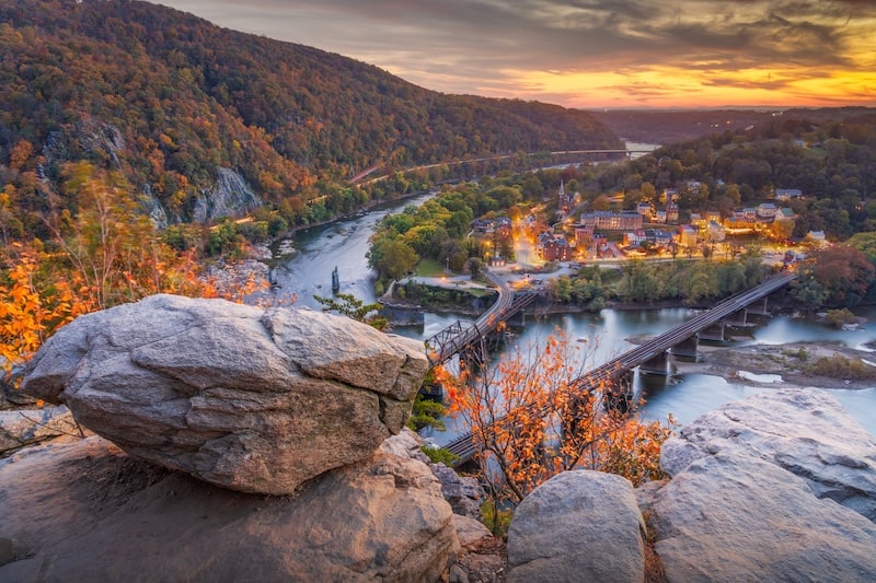 Scenic sunset view of Harpers Ferry, West Virginia, from an overlook with autumn foliage.