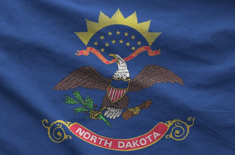 North Dakota state flag with bald eagle emblem and Latin motto